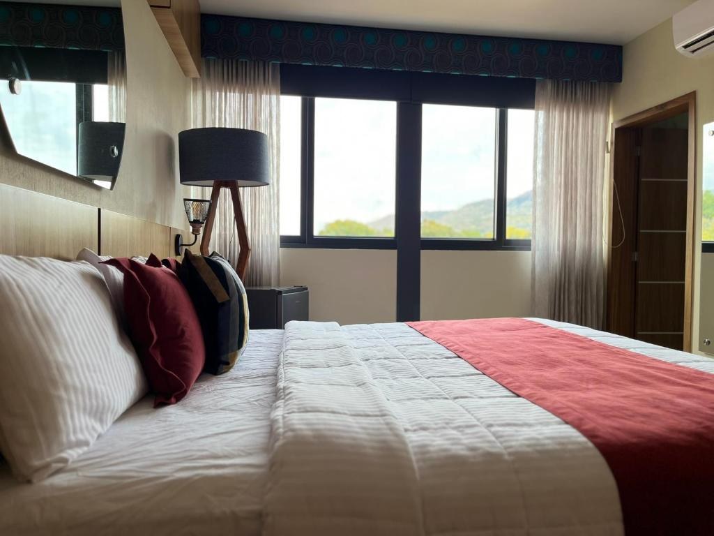A comfortable room at Hotel Cinco Diamantes, with white bedding and mountain views
